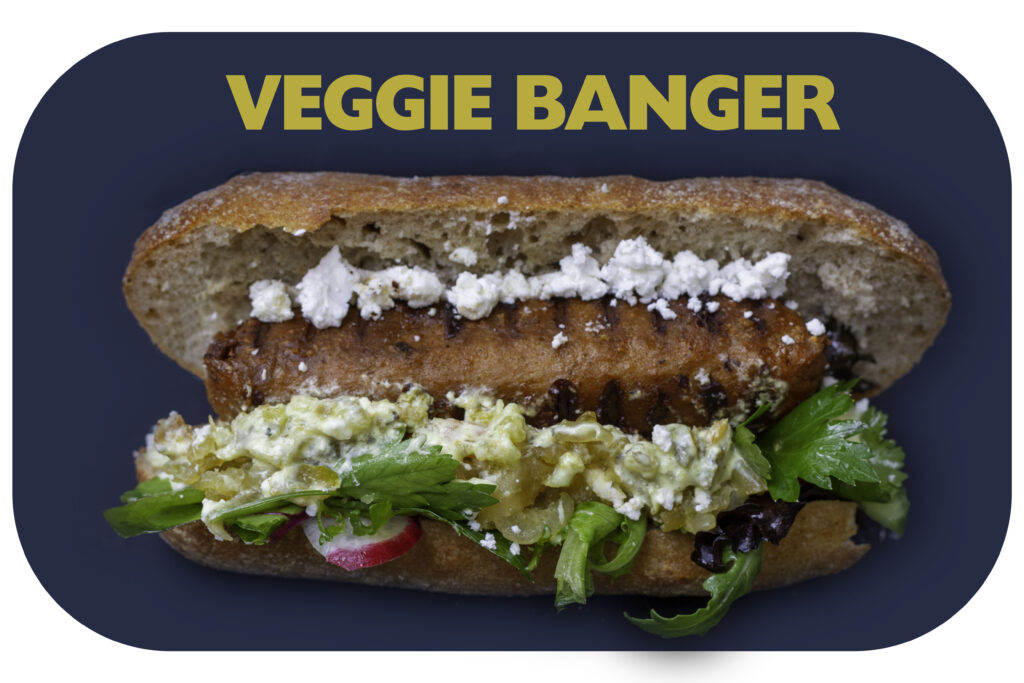 "Vegetarian Banger" Gourmet plant-based sausage, served with confit onion and apple, roasted capsicum, crumbled feta, mixed salad and Persian yoghurt dressing.